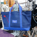 16oz Canvas Crew Tote in Navy and Royal hanging from the pin rail of a classic yacht