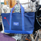 16oz Canvas Crew Tote in Navy and Royal hanging from the pin rail of a classic yacht