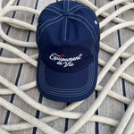 Contrast Stitch Cap in Navy laid on coiled rope on a teak deck